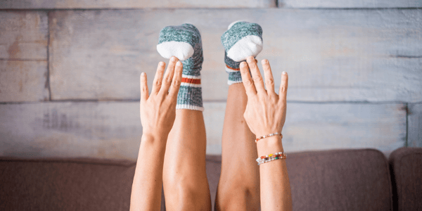 Mains qui tentent de rejoindre les pieds d'une personne couchée sur le dos