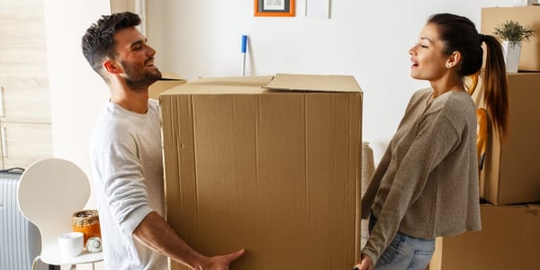 Homme et femmes qui tiennent une grosse boite en carton