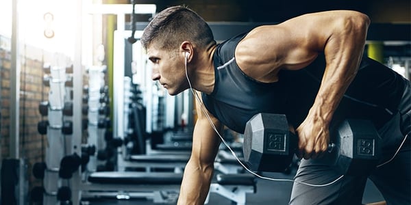 Homme qui soulève une haltère dans un gym