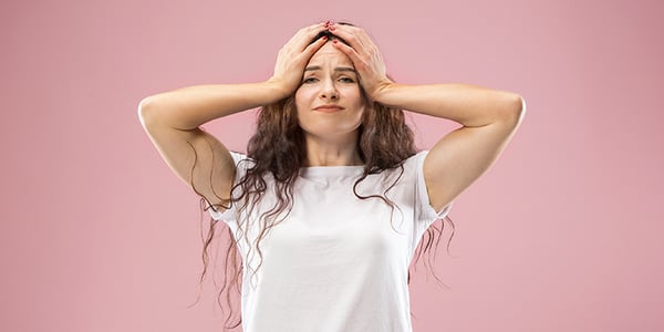 Femme qui se tient la tête à deux mains