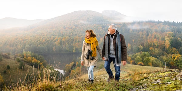 Femme et homme qui marchent en montagne en se tenant la main