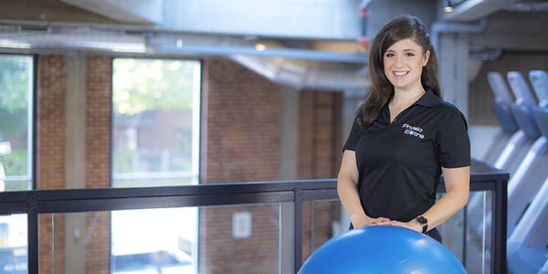 Femme derrière un ballon avec polo PhysioExtra