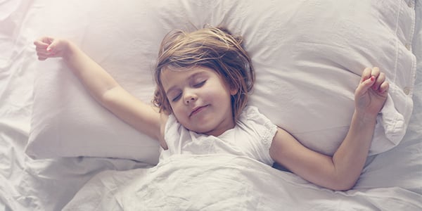 Enfant couchée sur le dos dans un lit
