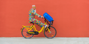 Homme en vêtements colorés à bicyclette