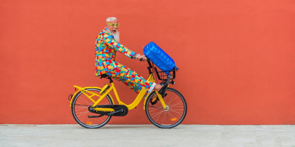 Homme en vêtements colorés à bicyclette