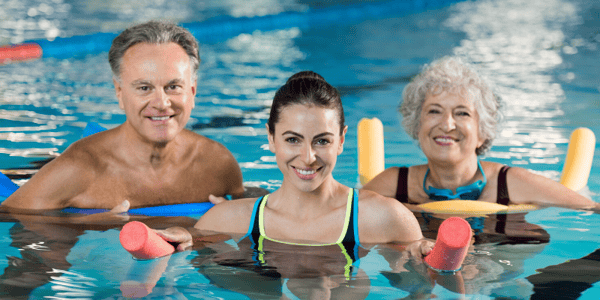 Femmes et homme dans une piscine avec accessoires d'exercice