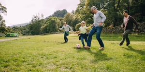 Homme avec 2 enfants qui jouent avec un ballon de soccer