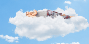 Woman in pyjamas sleeping on a cloud