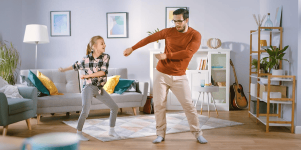 Adulte et enfant qui danse dans un salon